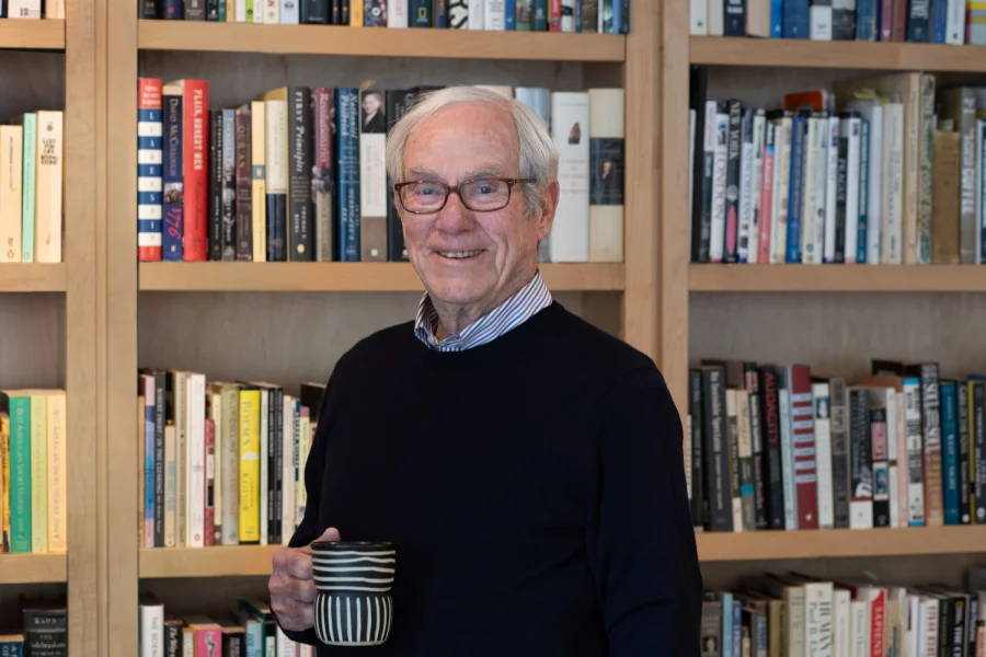 Jack in library with coffee and books