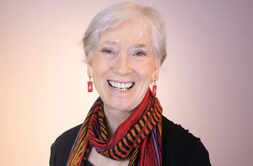 Elderly woman smiling wearing a scarf