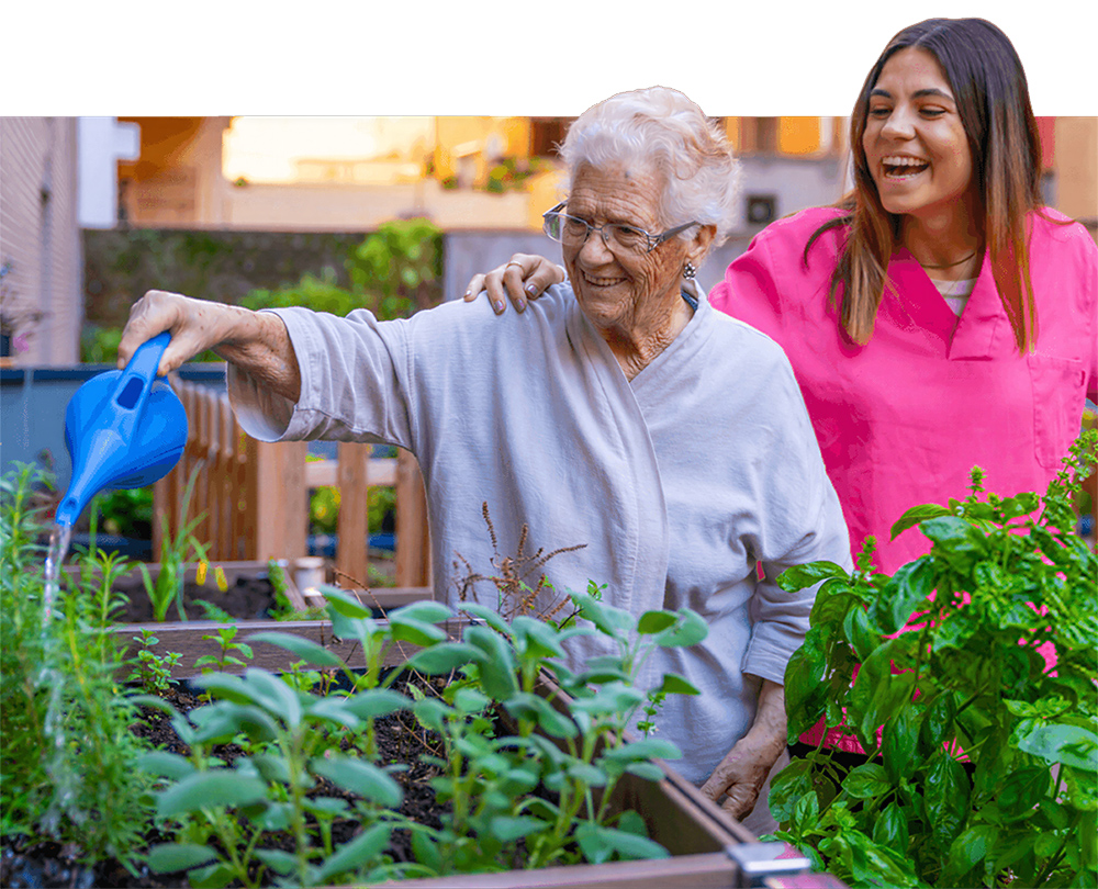 Senior woman watering plants outside.