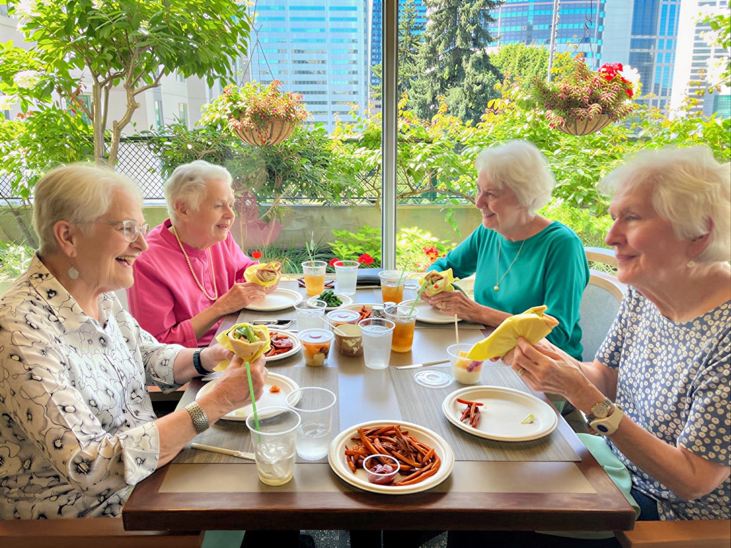senior women enjoying lunch next to a sunny window