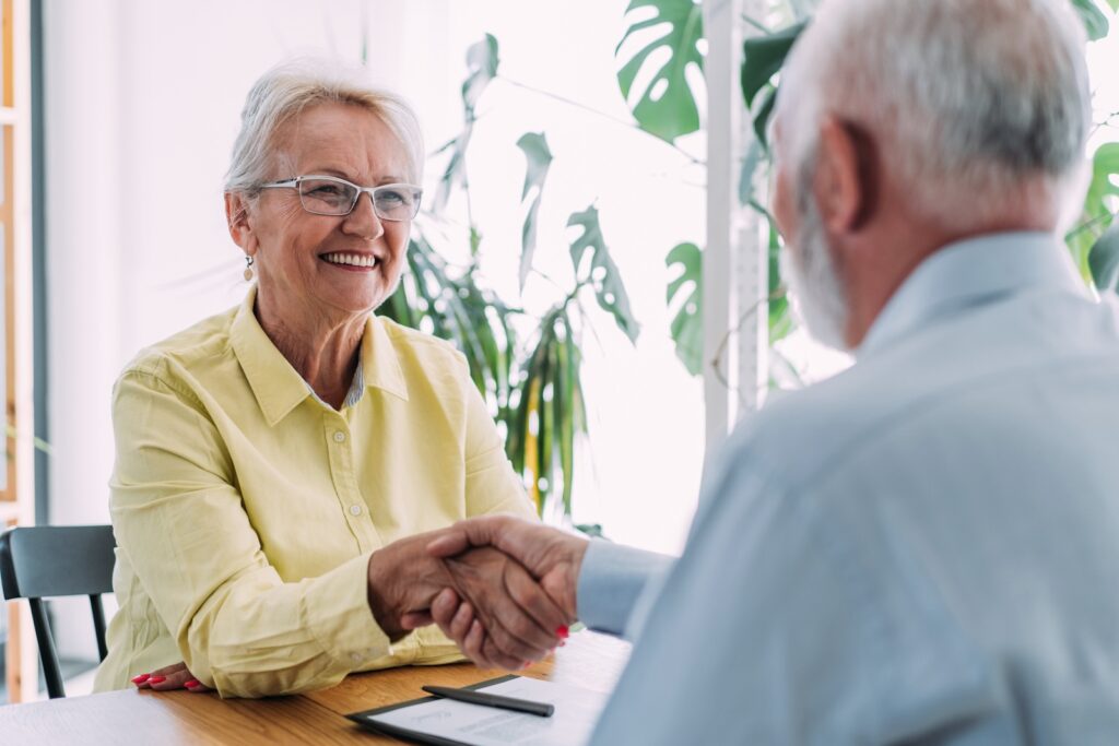 Seniors shaking hands in an office